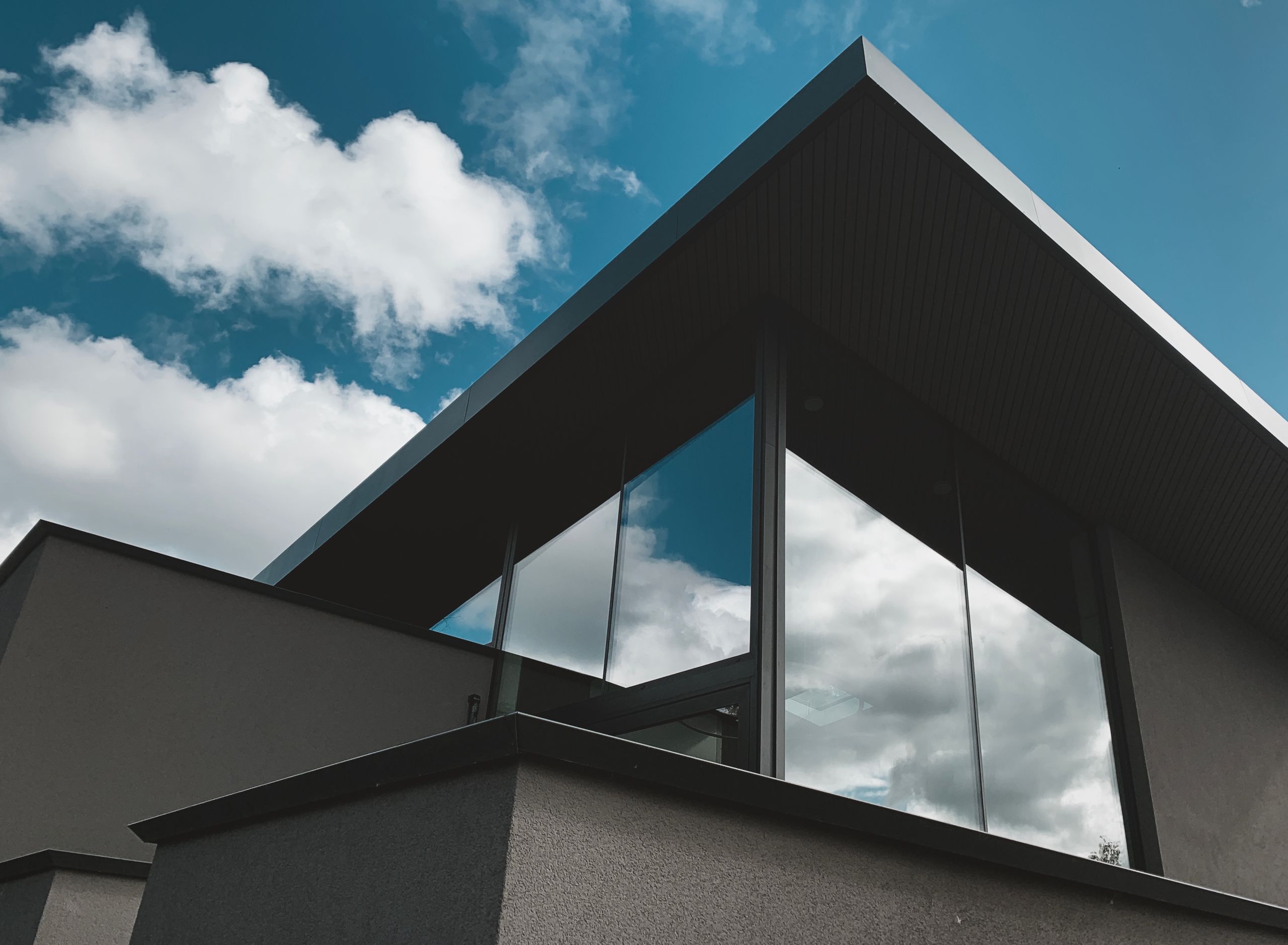 Contemporary architectural facade with glass reflections against a bright sky in Alkmaar, Netherlands.