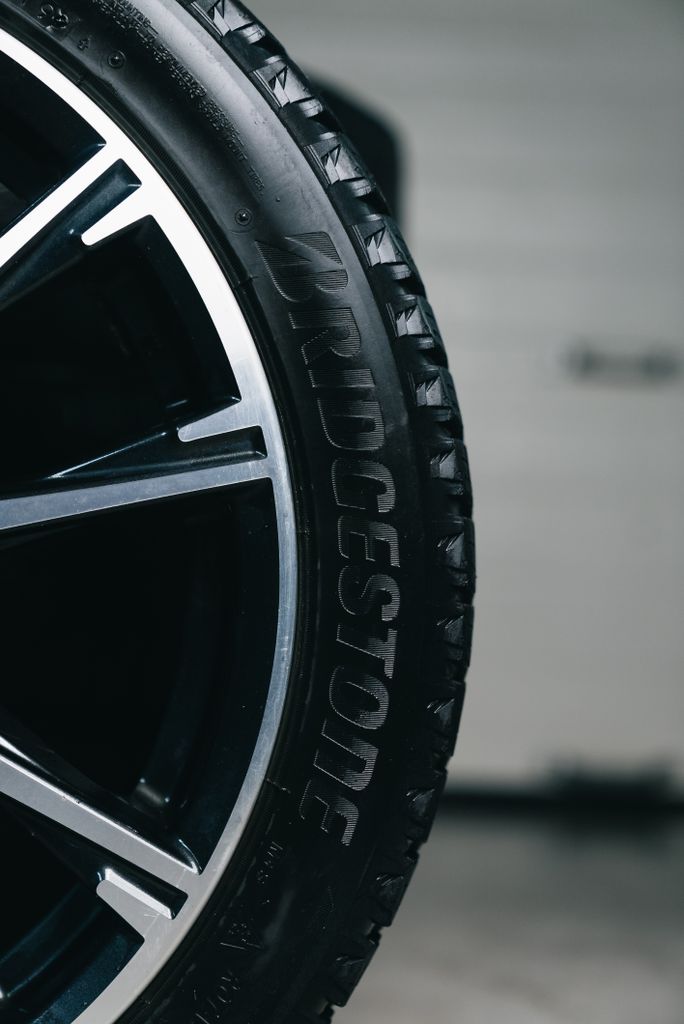 Detailed close-up of a Bridgestone tire mounted on a vehicle, showcasing tread and branding.
