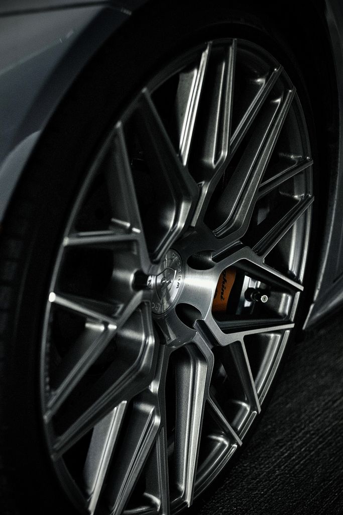 Detailed view of a silver sports car wheel and rim design, emphasizing elegance.
